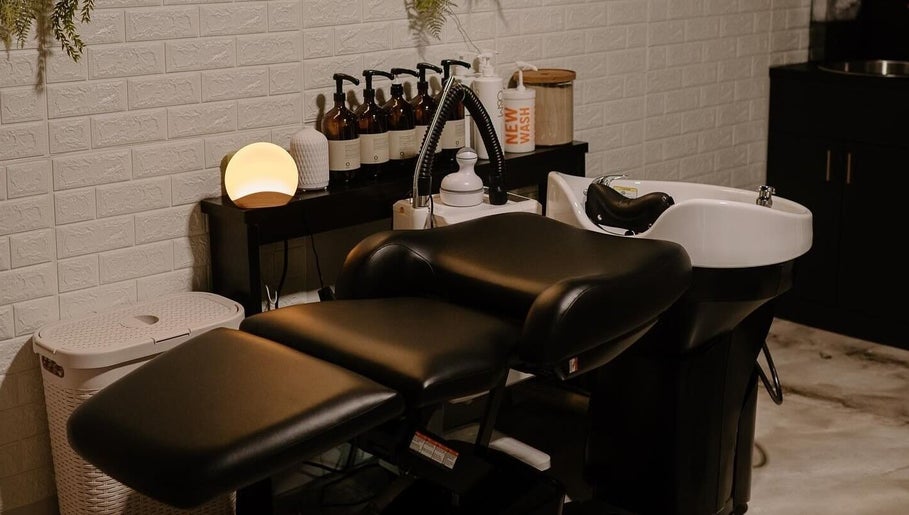 Relaxing salon corner at Mirrored by Melissa, Webster, New York, US with a modern hair wash station.