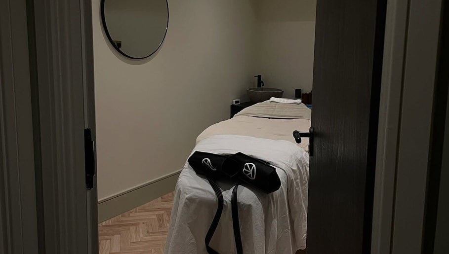 Cozy treatment room at Charlie Perry Skin, London, England, GB. Features a peaceful massage bed with ambient lighting.