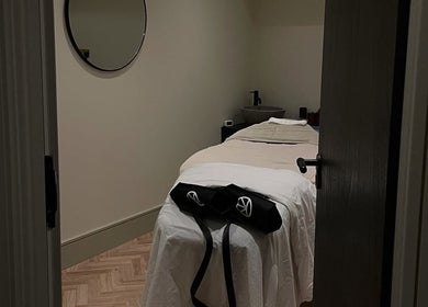 Cozy treatment room at Charlie Perry Skin, London, England, GB. Features a peaceful massage bed with ambient lighting.