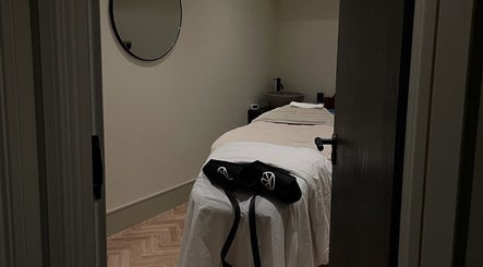 Cozy treatment room at Charlie Perry Skin, London, England, GB. Features a peaceful massage bed with ambient lighting.