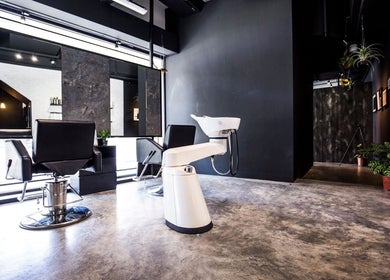Modern interior of SENTTEN. Japanese Hair Salon in Singapore, SG, featuring stylish chairs and a sleek wash station.