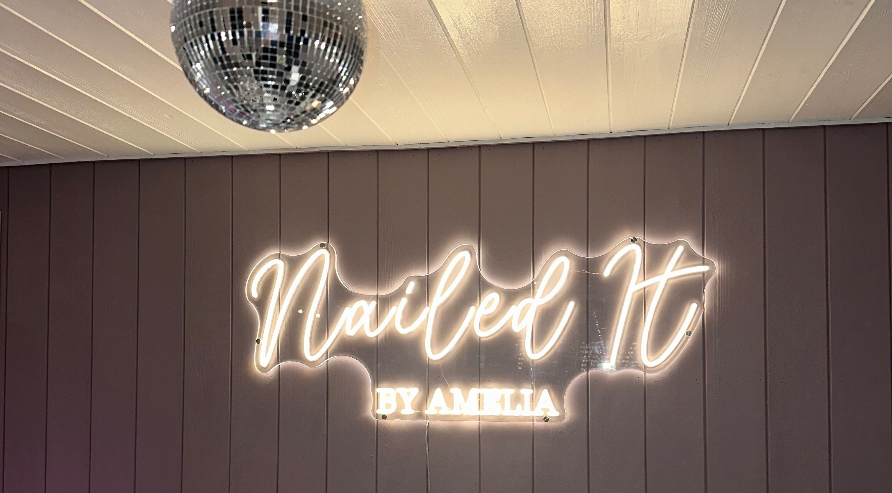 Neon sign of Nailed It by Amelia in Cheslyn Hay, England, GB under a sleek disco ball.