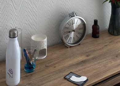 Stylish desk at Lashes & Brows By Lil, Hoddesdon, England, GB featuring clock and beauty tools.