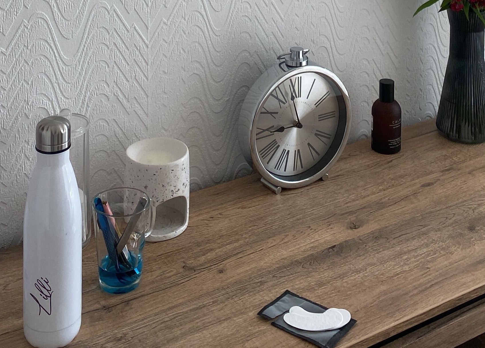 Stylish desk at Lashes & Brows By Lil, Hoddesdon, England, GB featuring clock and beauty tools.