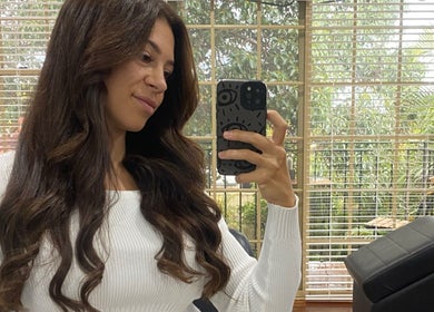 Client enjoying her hairstyle at Kalon Hair Perth in a bright, serene salon room, Perth, Western Australia, AU.