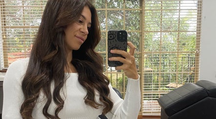Client enjoying her hairstyle at Kalon Hair Perth in a bright, serene salon room, Perth, Western Australia, AU.