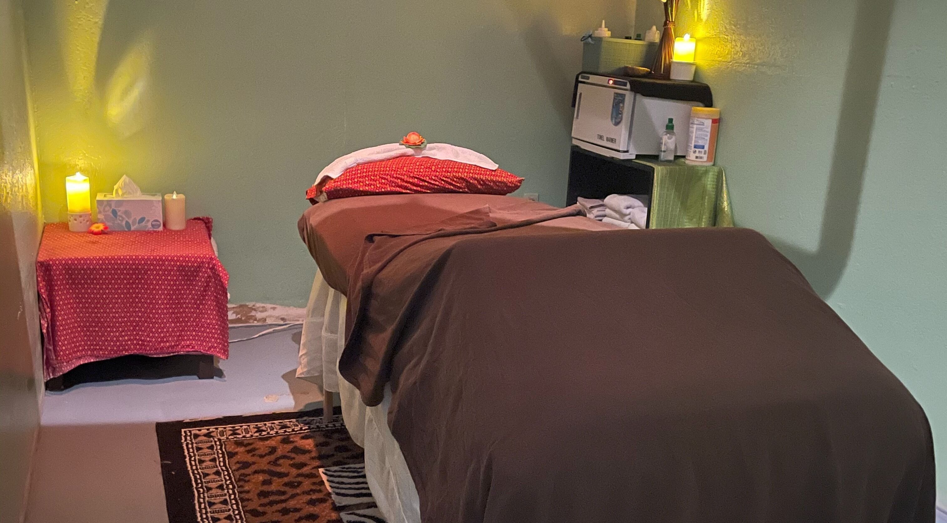 Cozy massage room at Aiyara Thai Massage Prescott Valley, Prescott Valley, Arizona, US, with ambient lighting and candles.
