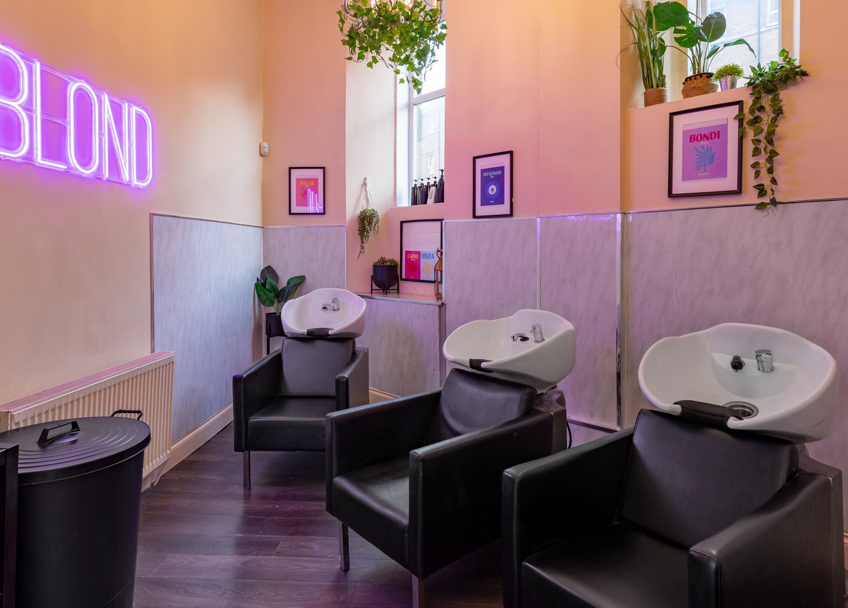 Modern wash stations at BLOND Salon, Glasgow, Scotland, GB with sleek decor and neon lighting.