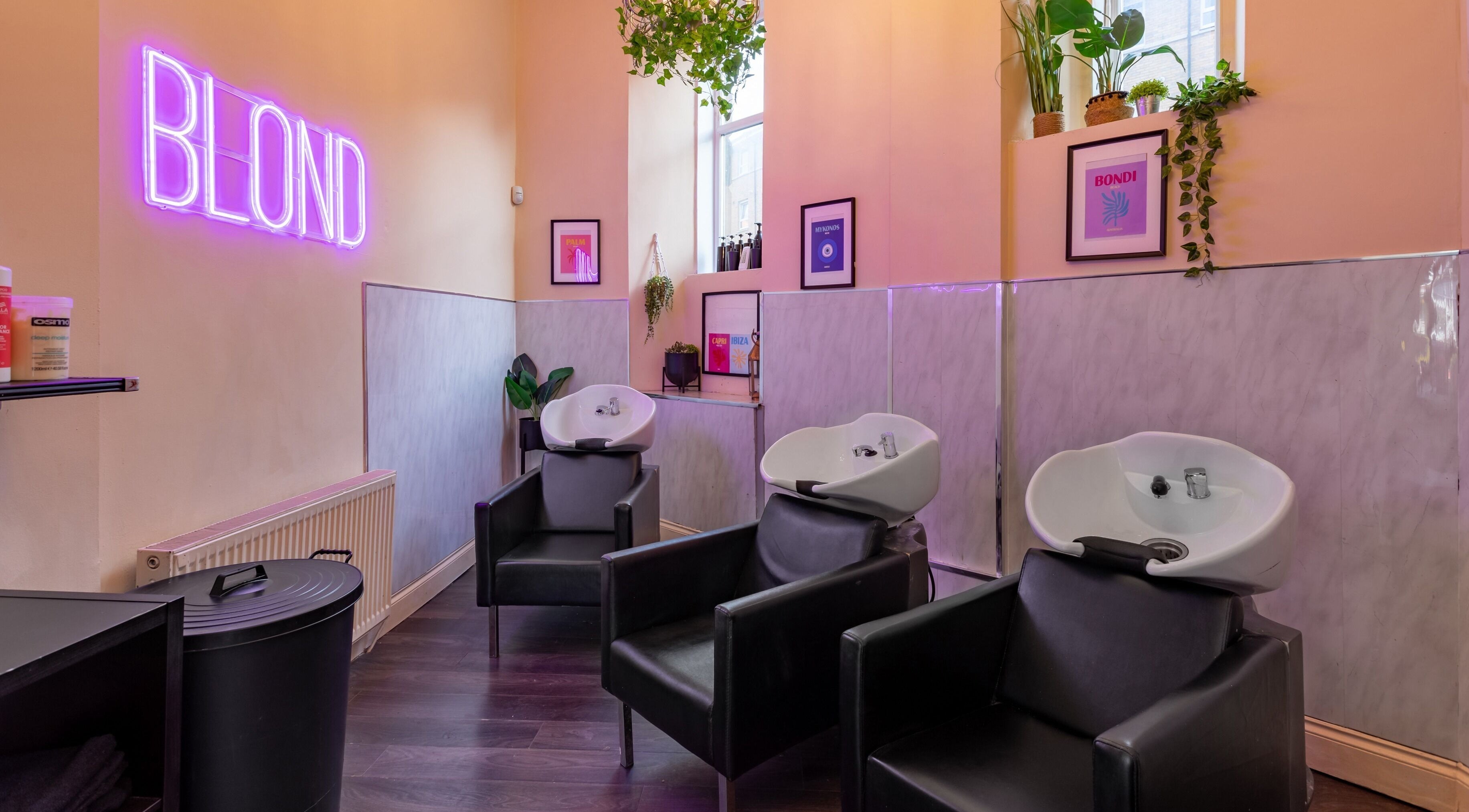 Modern wash stations at BLOND Salon, Glasgow, Scotland, GB with sleek decor and neon lighting.