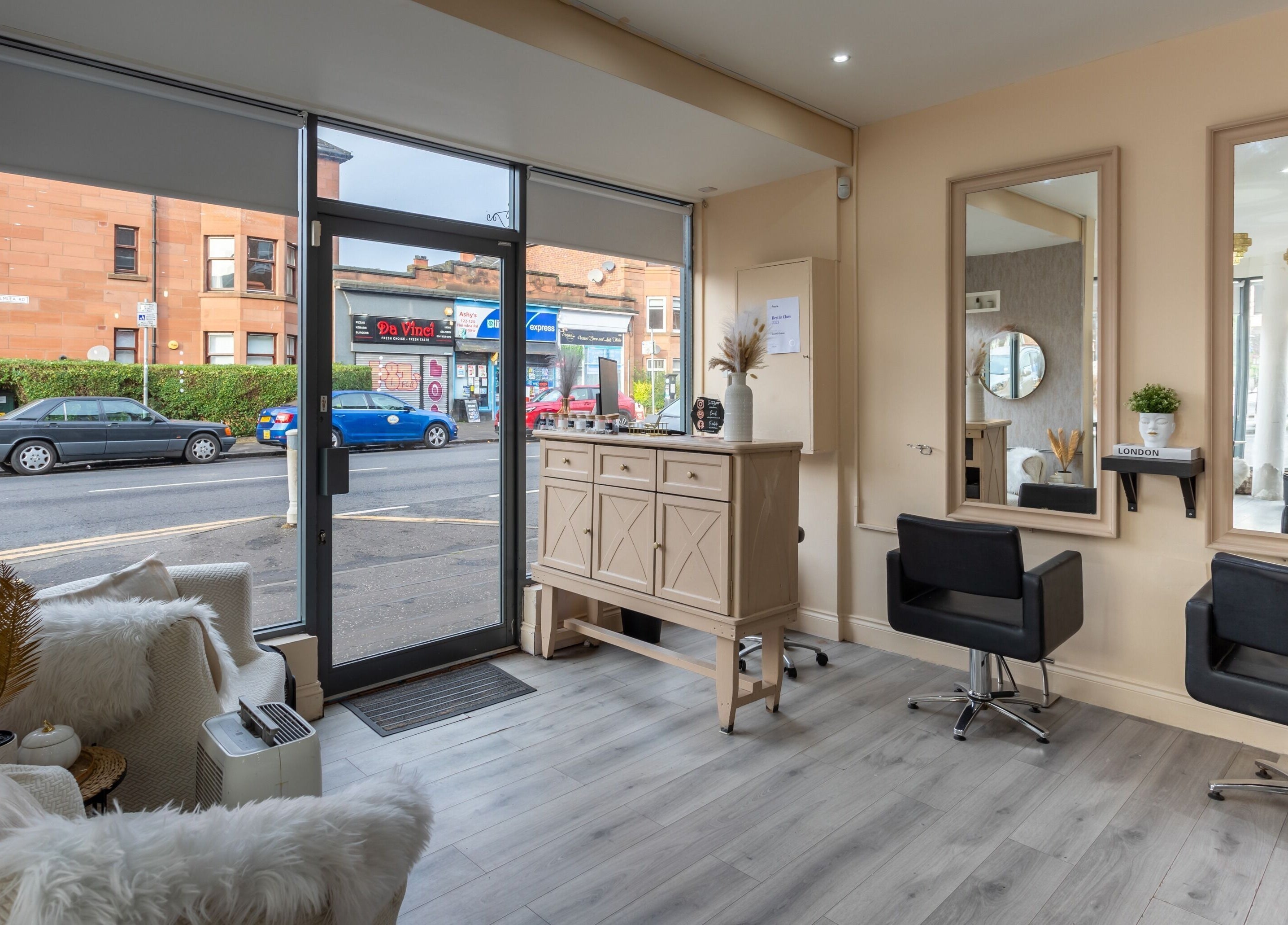 Interior of BLOND Salon in Glasgow, Scotland, showcasing elegant seating and styling stations with street view.
