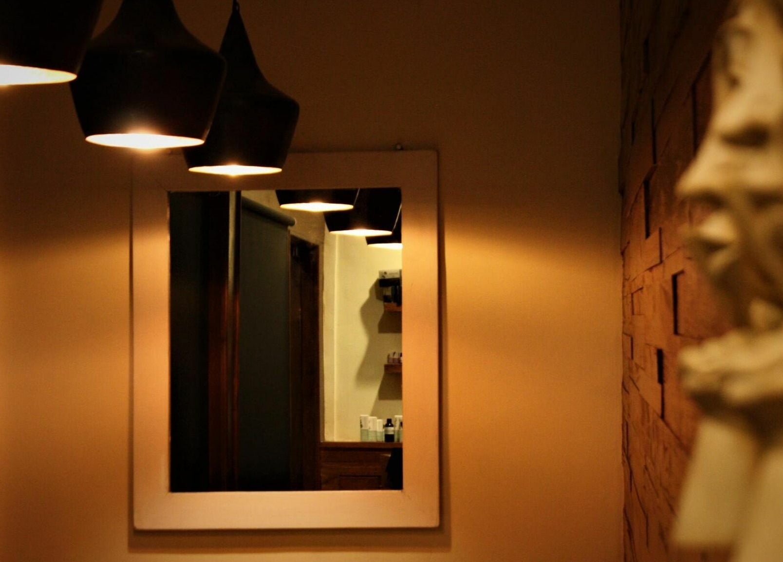 Warmly lit mirror reflecting serene ambiance at Laniakea Spa, Bali, Bali, ID.