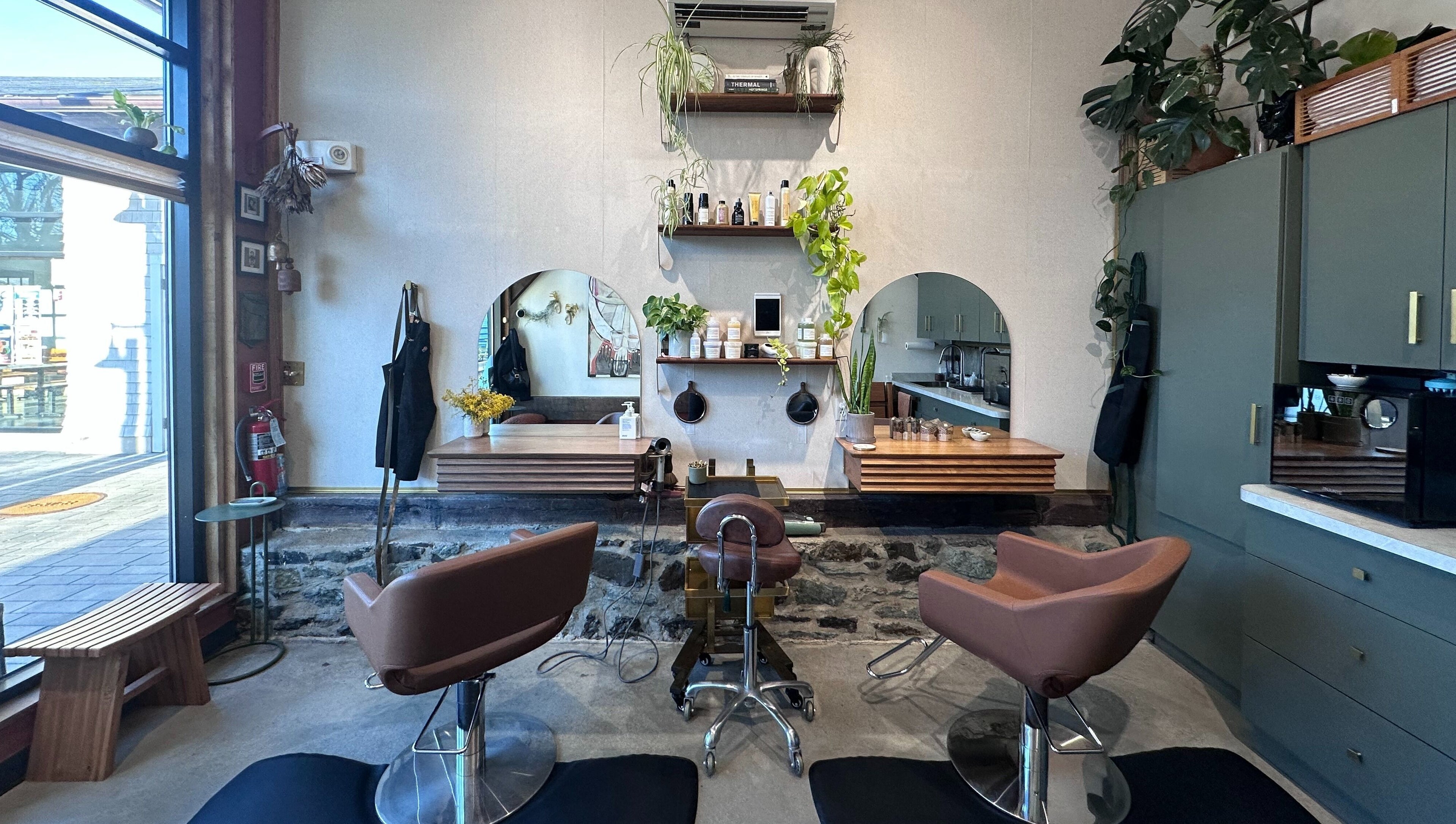 Modern interior of Bellwether Salon in Boston, Massachusetts, US with stylish chairs and lush greenery.