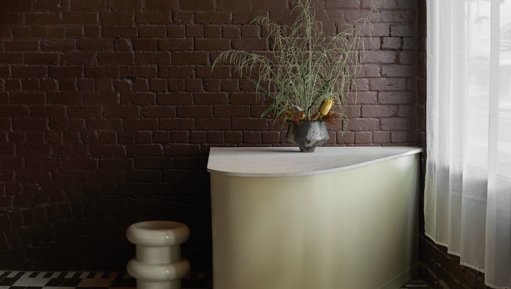 Stylish reception area at Nimbus Co Fitzroy, Melbourne, Victoria, AU with a modern desk and greenery.
