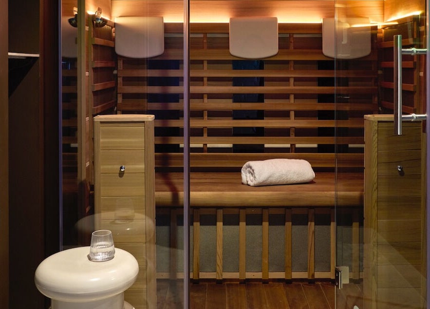 Luxurious sauna at Nimbus Co Fitzroy, Melbourne, Victoria, AU, with wooden interiors and folded towel.
