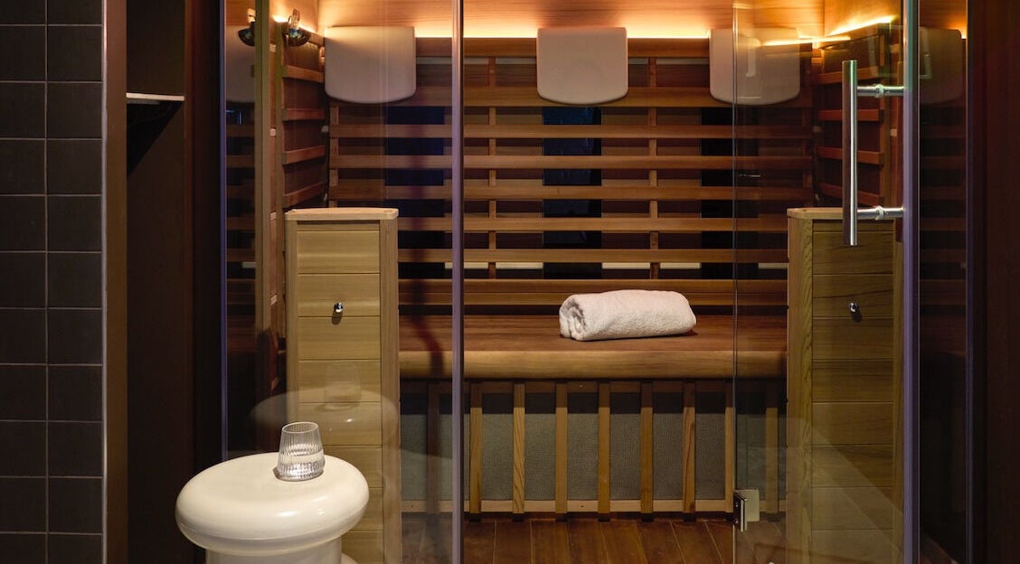 Luxurious sauna at Nimbus Co Fitzroy, Melbourne, Victoria, AU, with wooden interiors and folded towel.