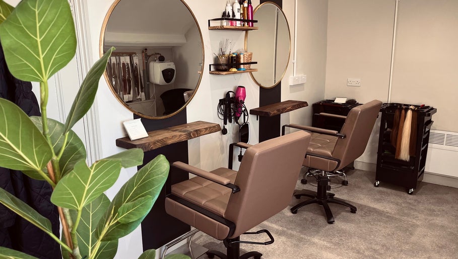 Modern salon interior at Rigs Wigs in Holywood, Northern Ireland, GB with stylish chairs and mirrors.
