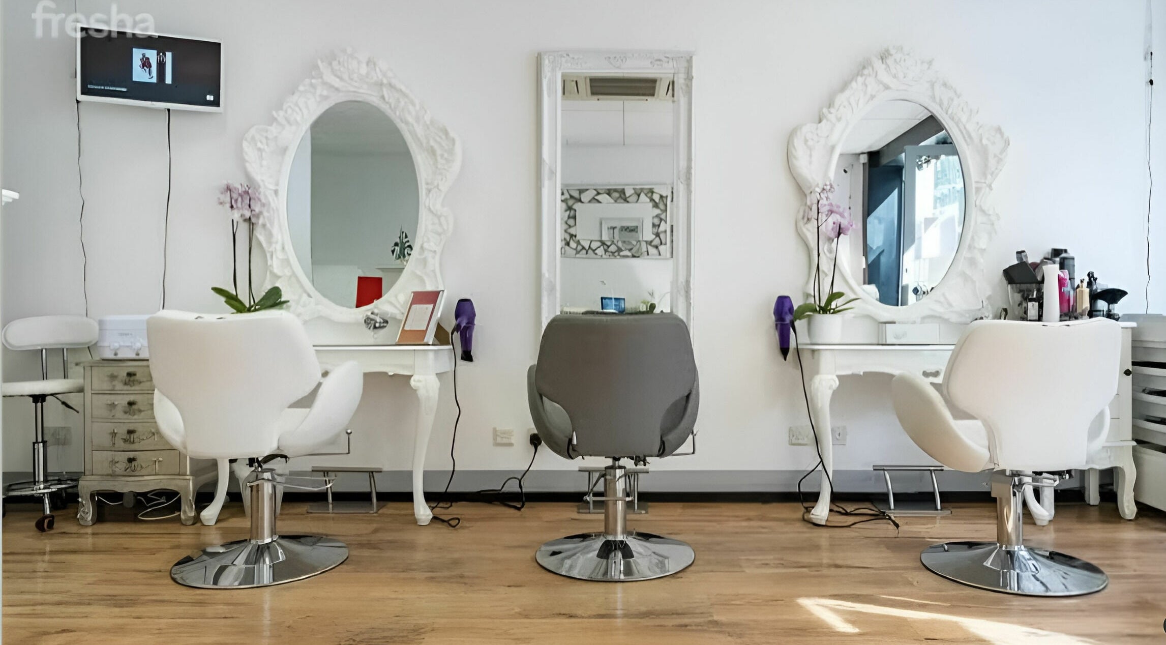 Elegant salon setup at Beauty by Fabi, Camberley, England, GB featuring modern chairs and ornate mirrors.