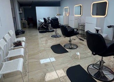 Interior del salón Pelokitoz en Caguas, Caguas, PR con sillas modernas y espejos iluminados.