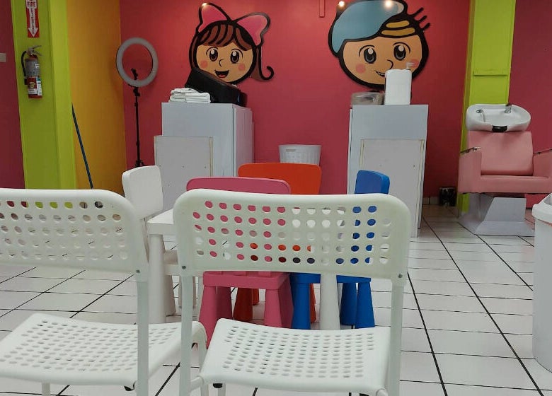 Interior colorido del salón Pelokitoz en Caguas, Caguas, PR, con sillas y decoración vibrante.