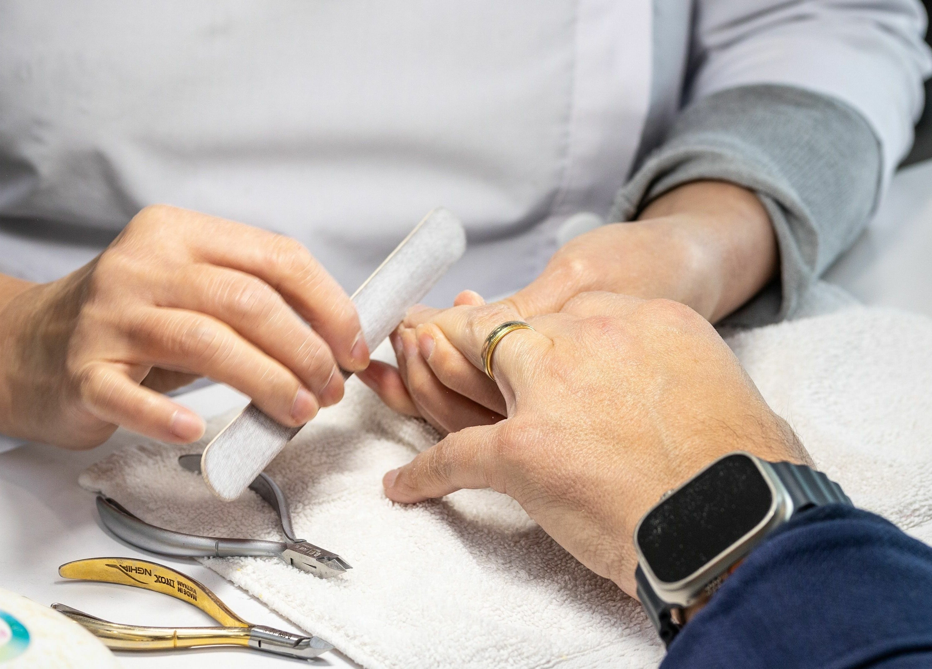 Professional manicure at Tmr Nails Bar, Mont-Royal, Québec, CA showcasing a nail technician filing nails.