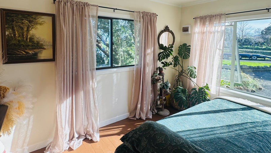 Sunlit room at Honey & Ginger Beauty, Te Aroha, Waikato, NZ, featuring lush plants and elegant decor.