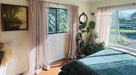 Sunlit room at Honey & Ginger Beauty, Te Aroha, Waikato, NZ, featuring lush plants and elegant decor.