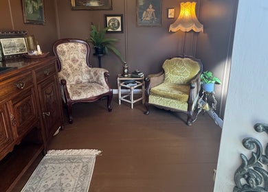 Cozy vintage lounge at Honey & Ginger Beauty, Te Aroha, Waikato, NZ with elegant armchairs and decor.