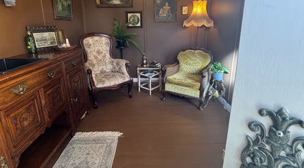 Cozy vintage lounge at Honey & Ginger Beauty, Te Aroha, Waikato, NZ with elegant armchairs and decor.
