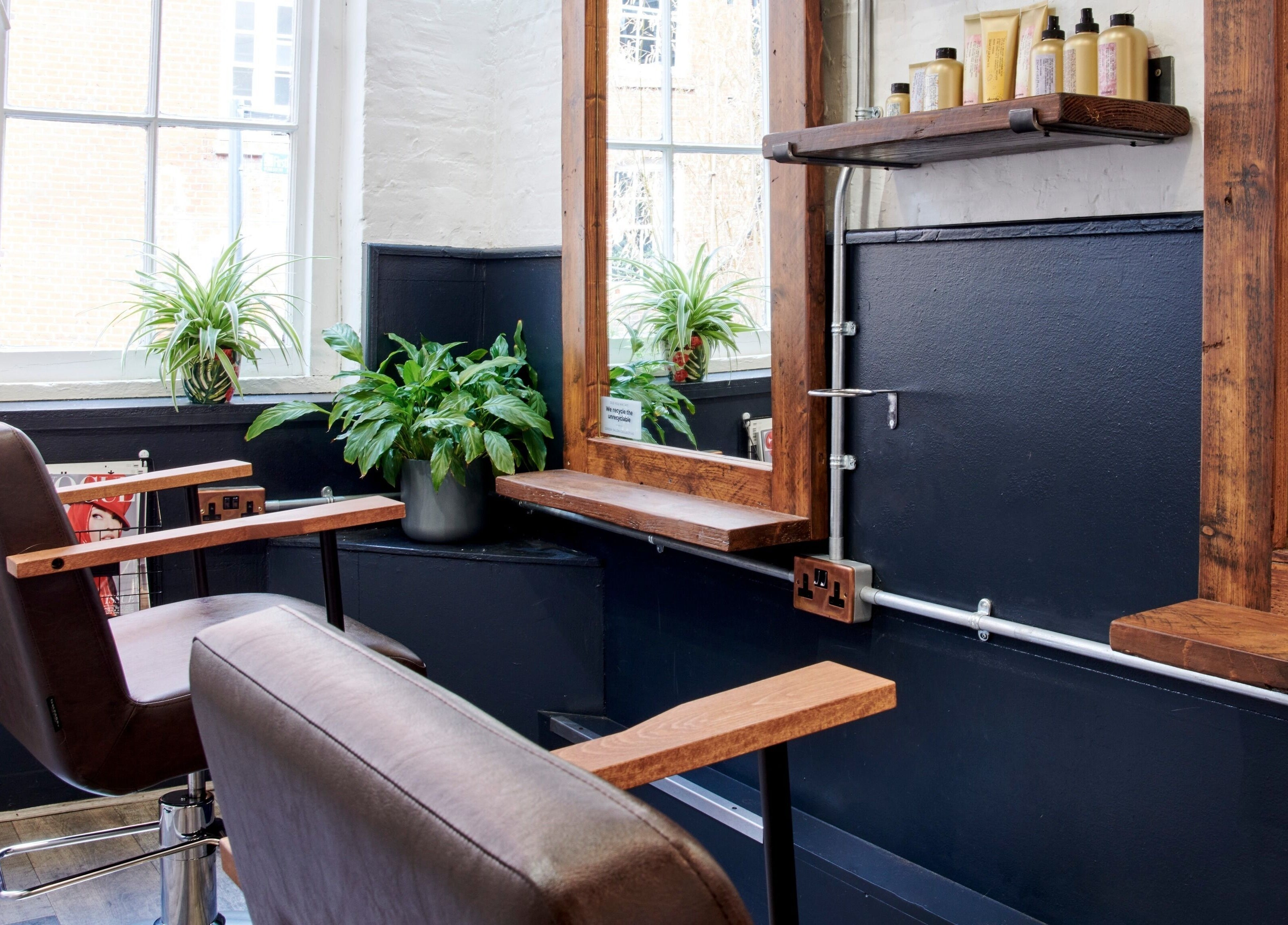 Stylish seating area at Notice Hair Salon, London, England, GB with modern decor and plants.