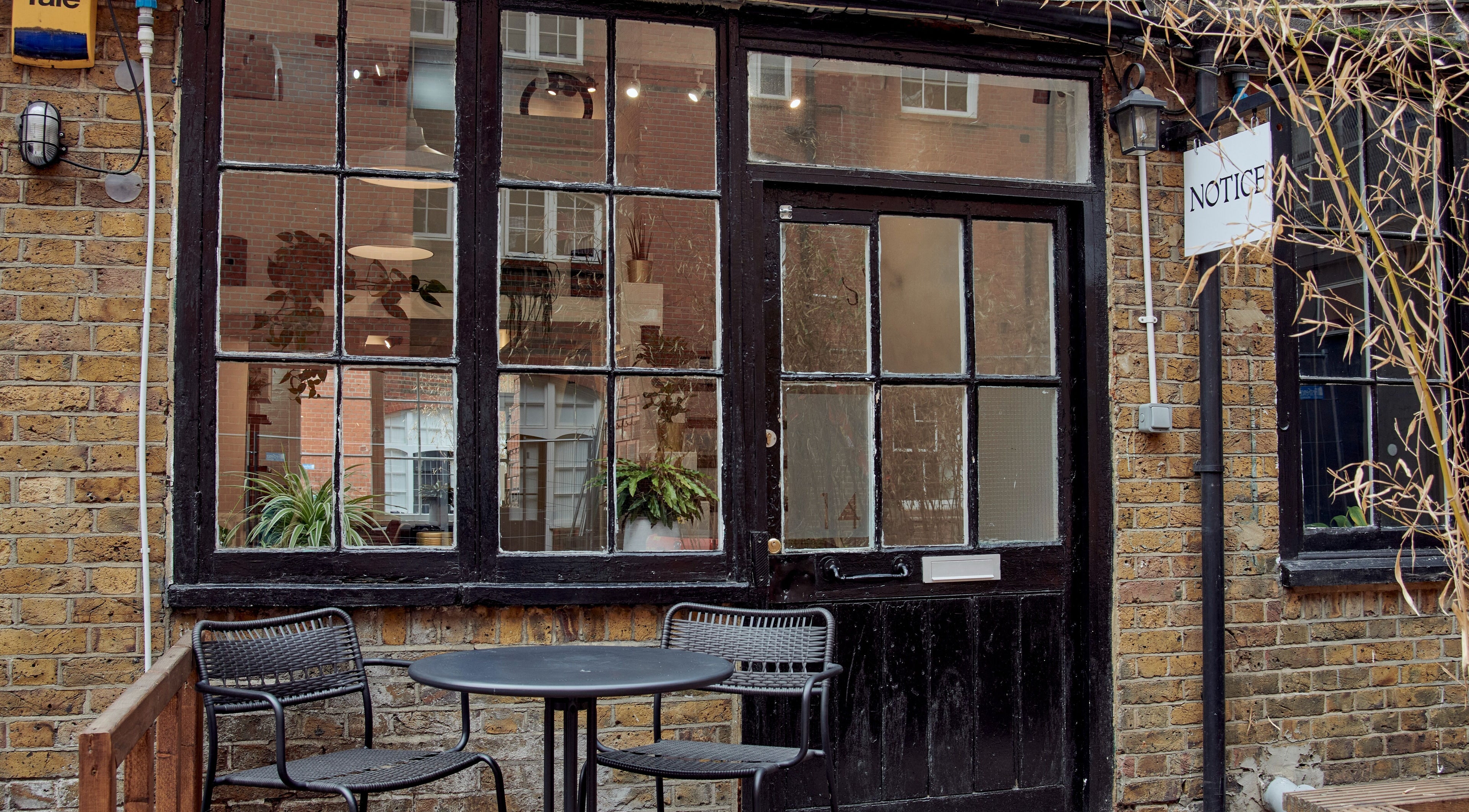 Entrance of Notice Hair Salon in London, England, GB with a cozy outdoor seating area.