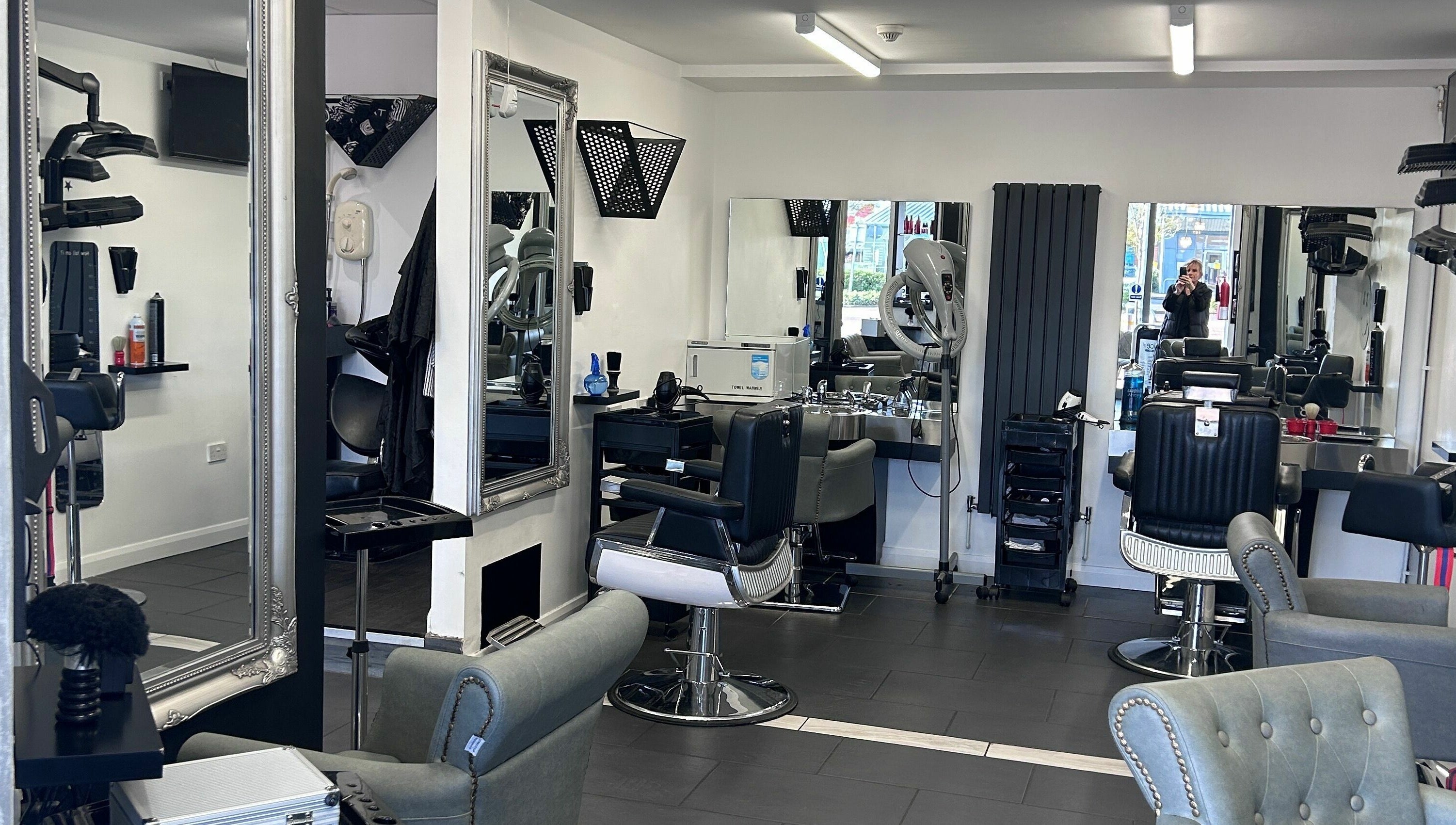 Modern and stylish interior of Ice Hair and Barbers in Quedgeley, England, GB featuring chic barber chairs and mirrors.
