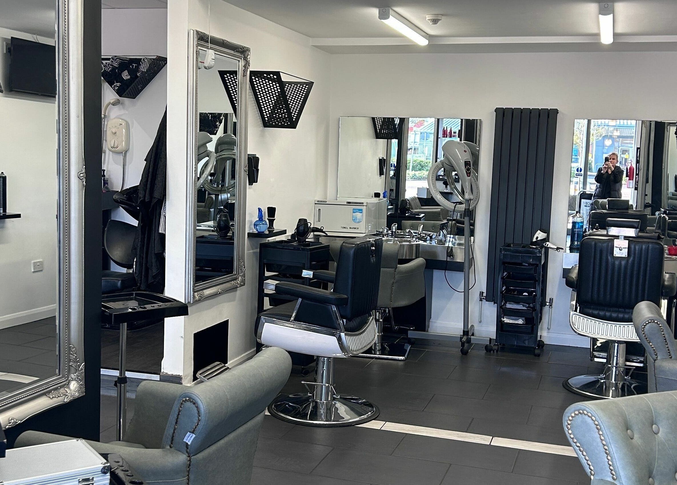Modern and stylish interior of Ice Hair and Barbers in Quedgeley, England, GB featuring chic barber chairs and mirrors.