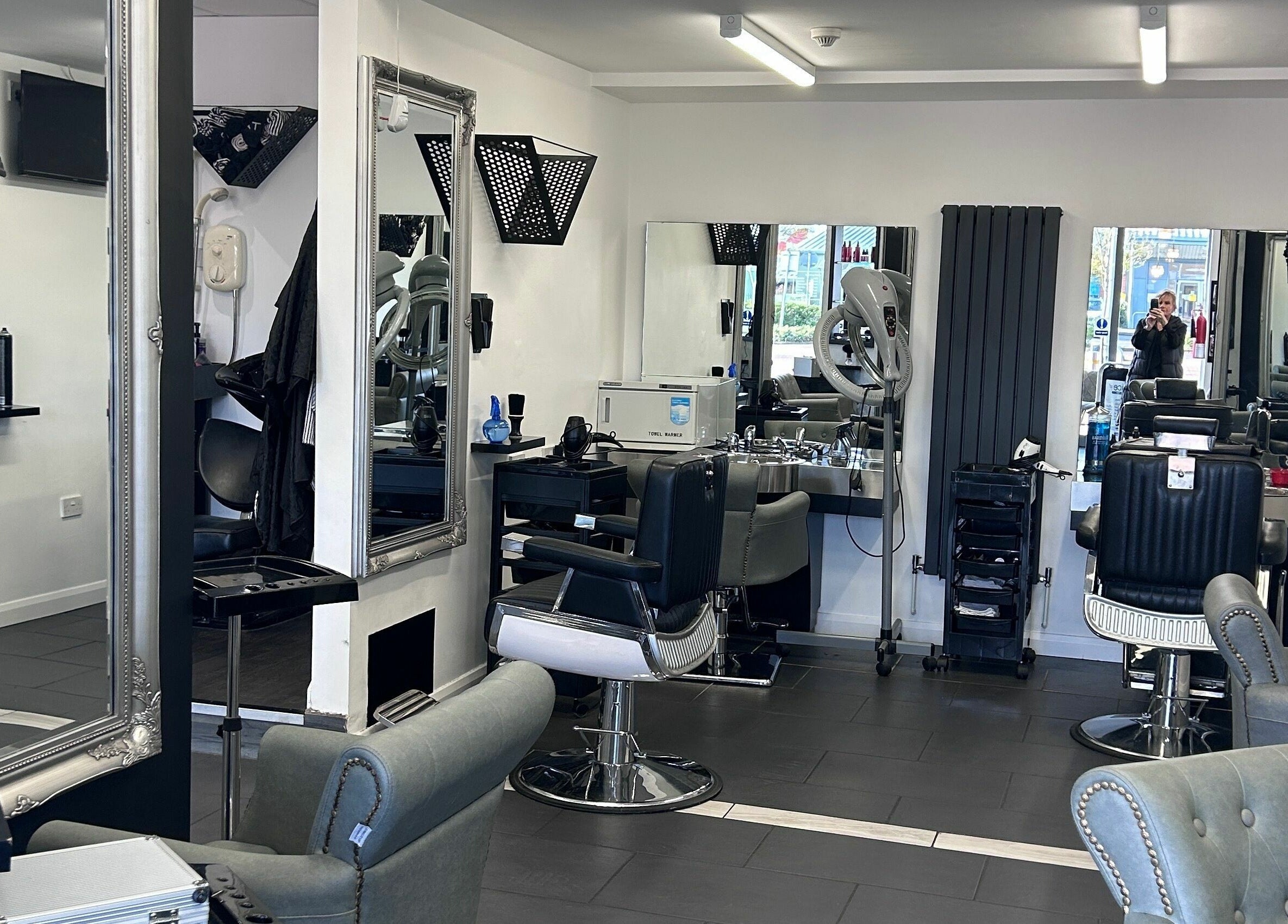Modern and stylish interior of Ice Hair and Barbers in Quedgeley, England, GB featuring chic barber chairs and mirrors.