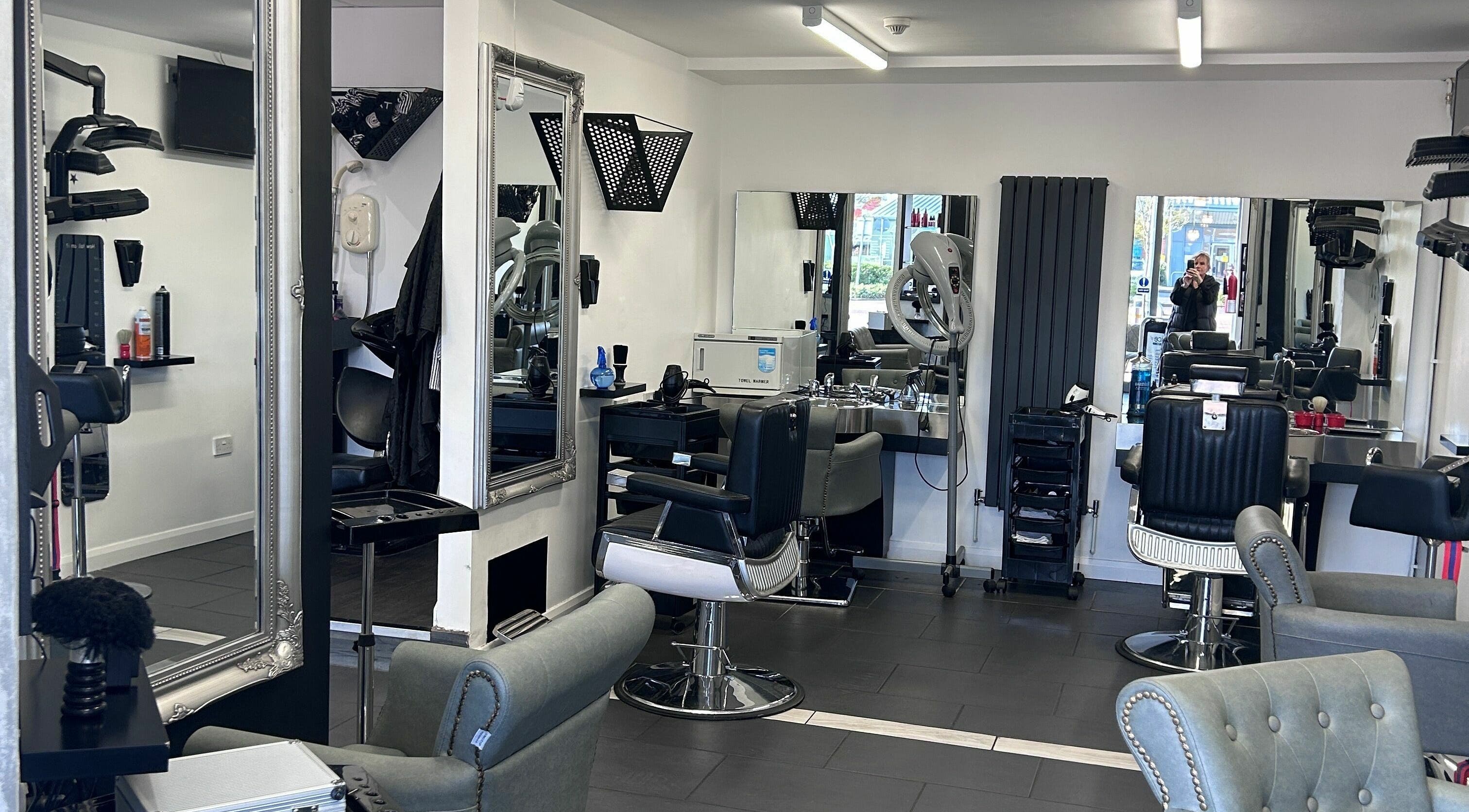 Modern and stylish interior of Ice Hair and Barbers in Quedgeley, England, GB featuring chic barber chairs and mirrors.