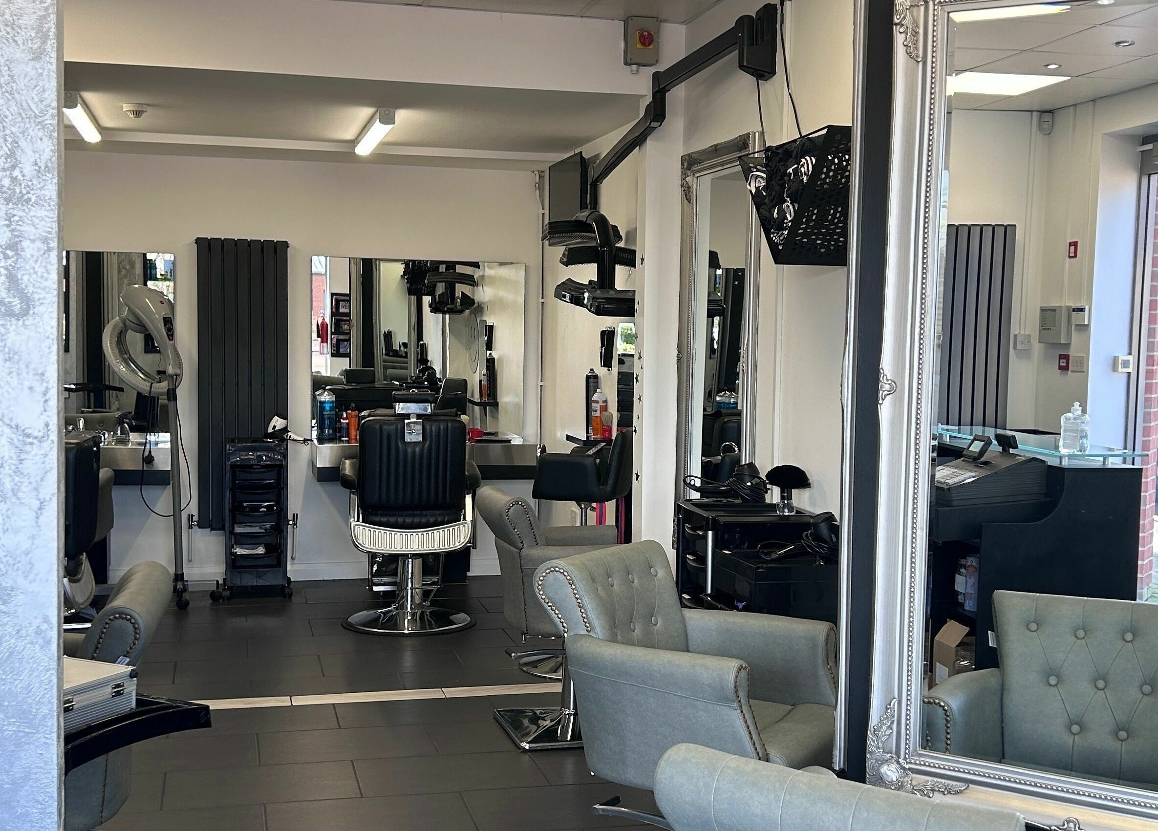 Interior of Ice Hair and Barbers, a modern salon in Quedgeley, England, GB with stylish chairs and mirrors.