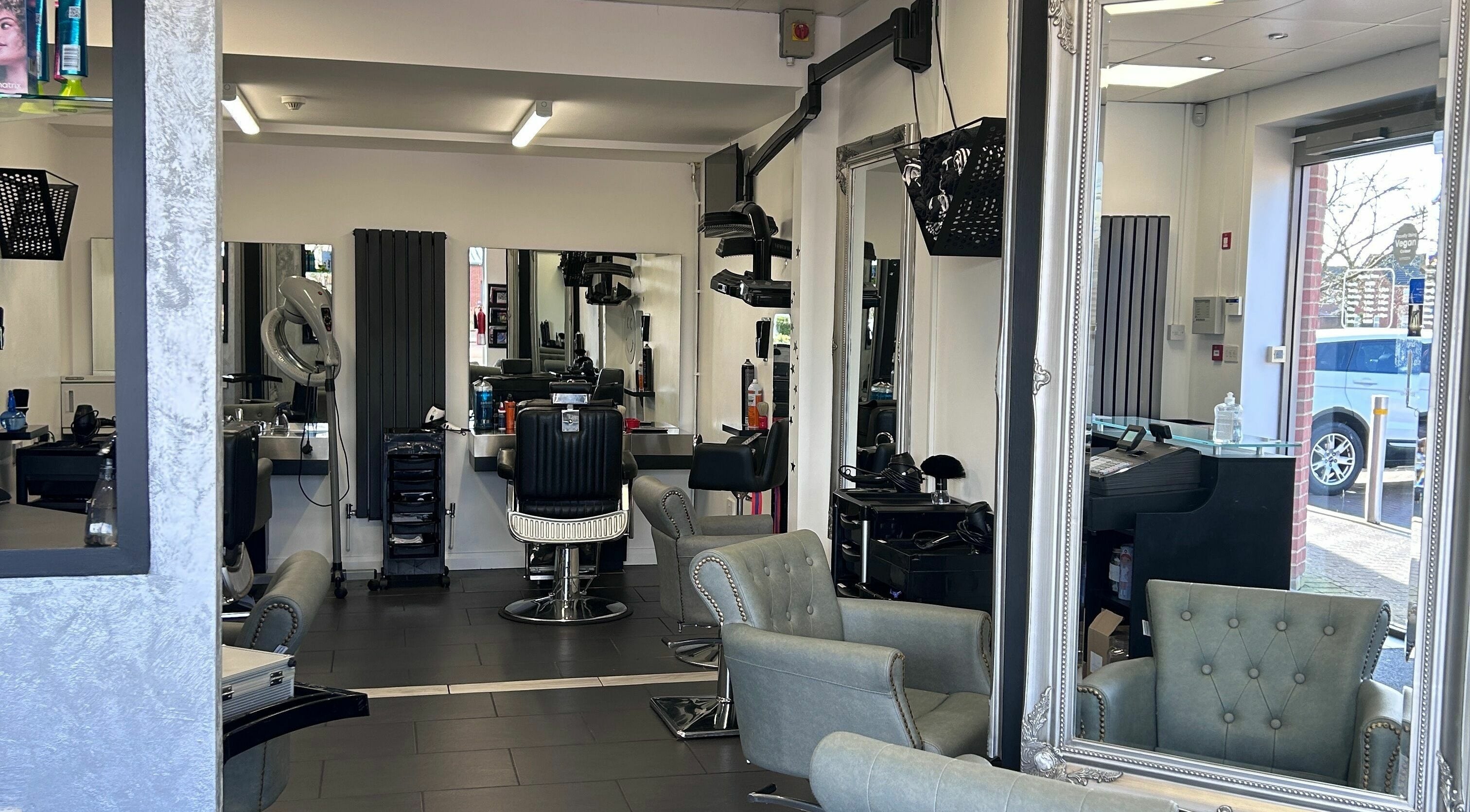 Interior of Ice Hair and Barbers, a modern salon in Quedgeley, England, GB with stylish chairs and mirrors.
