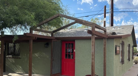 Inviting entrance of The Right Touch Massage LLC in Tucson, Arizona, US with red door and green facade.