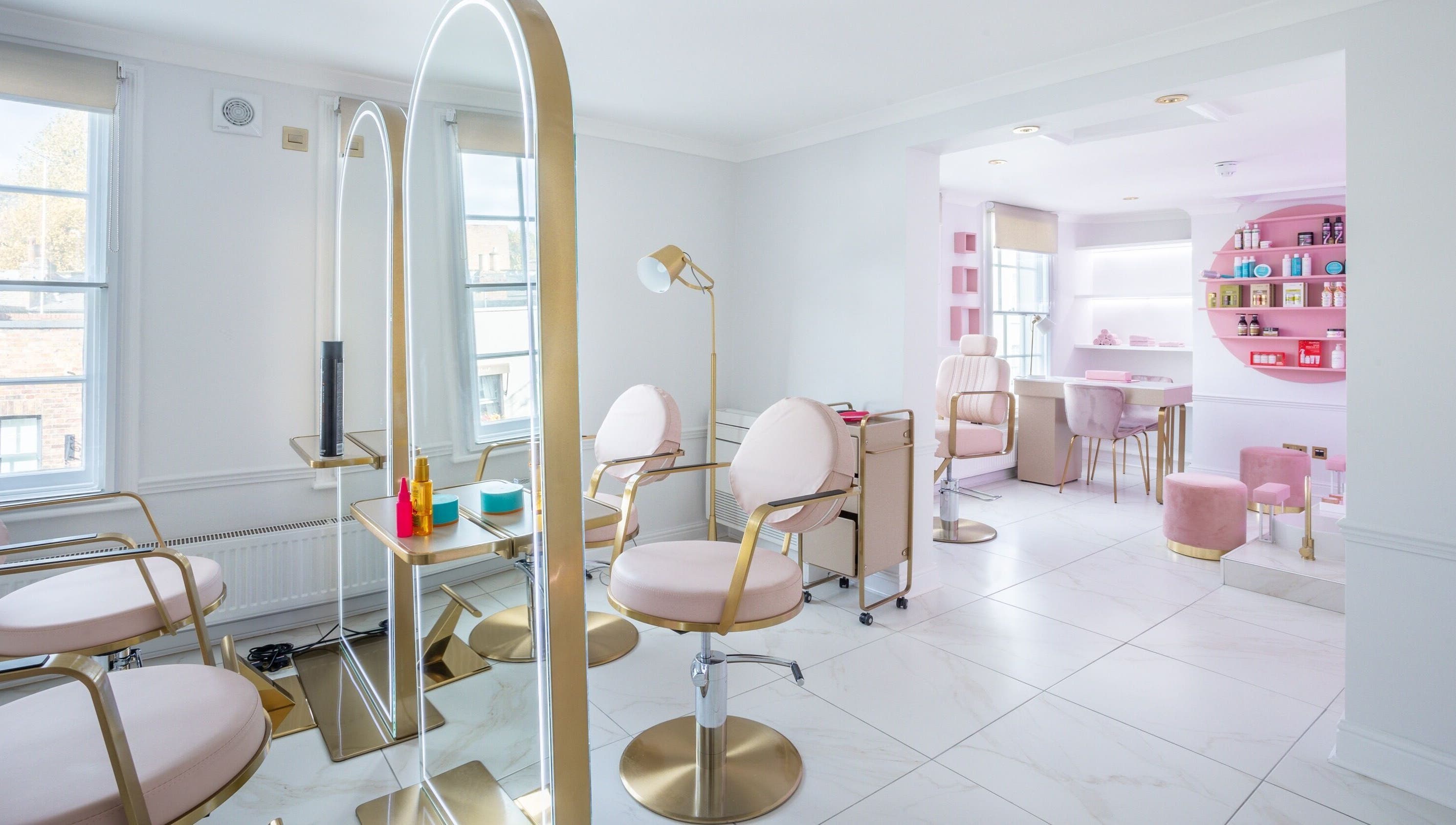 Elegant interior of The Dolls London SW3, London, England, GB. Modern beauty salon with stylish seating and decor.