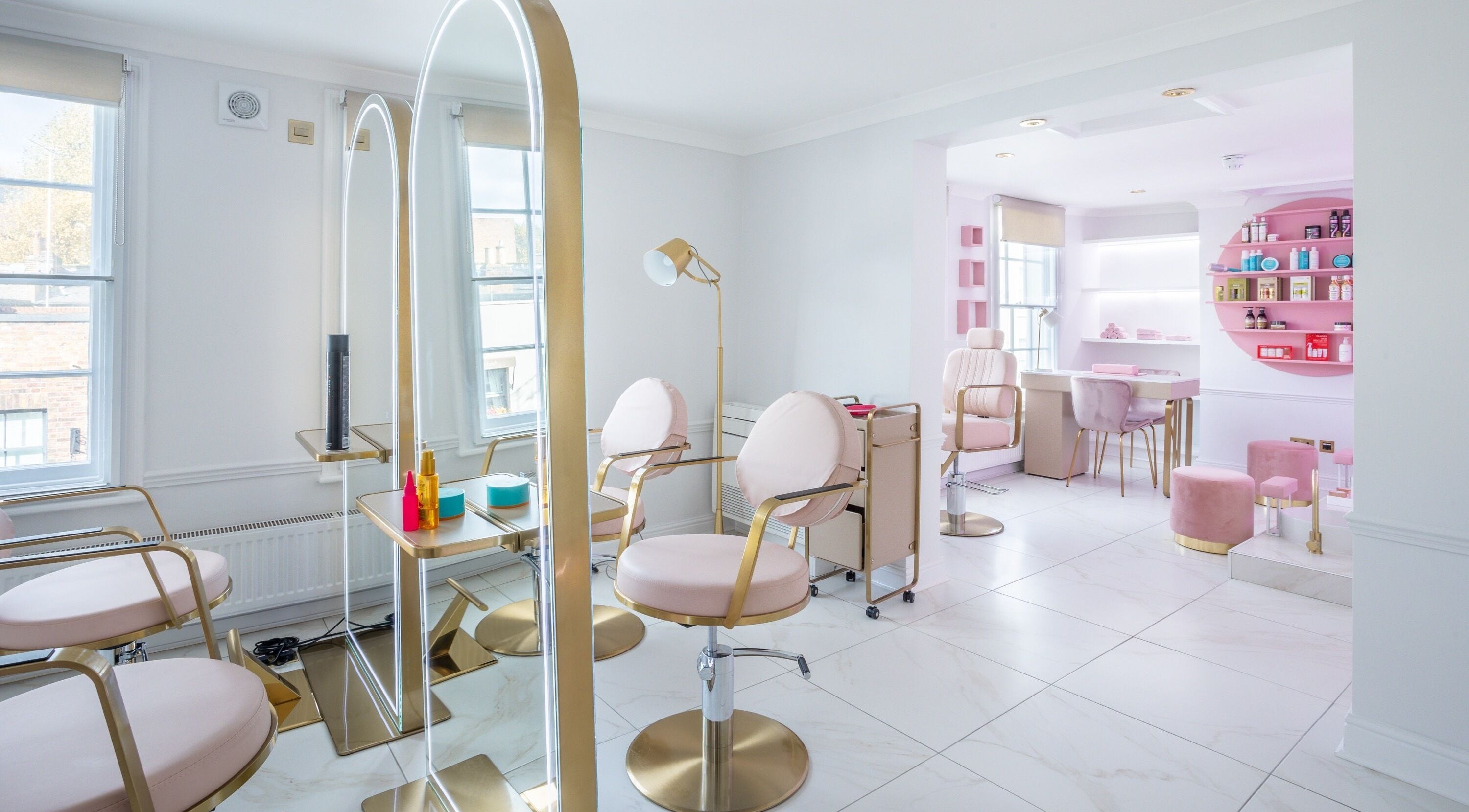 Elegant interior of The Dolls London SW3, London, England, GB. Modern beauty salon with stylish seating and decor.