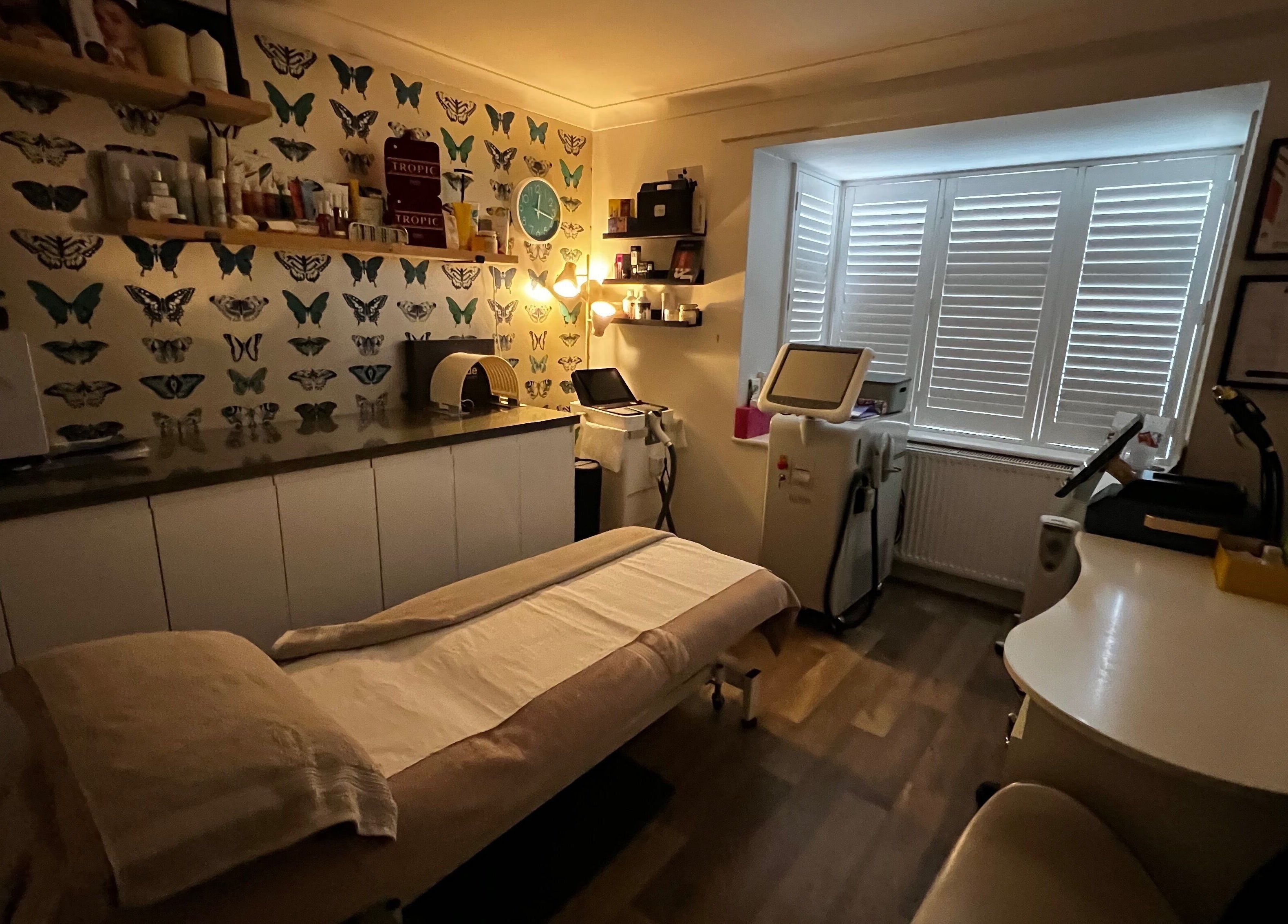 Cozy treatment room at Senses Beauty in Warwick, England, GB with butterfly decor and soothing lighting.