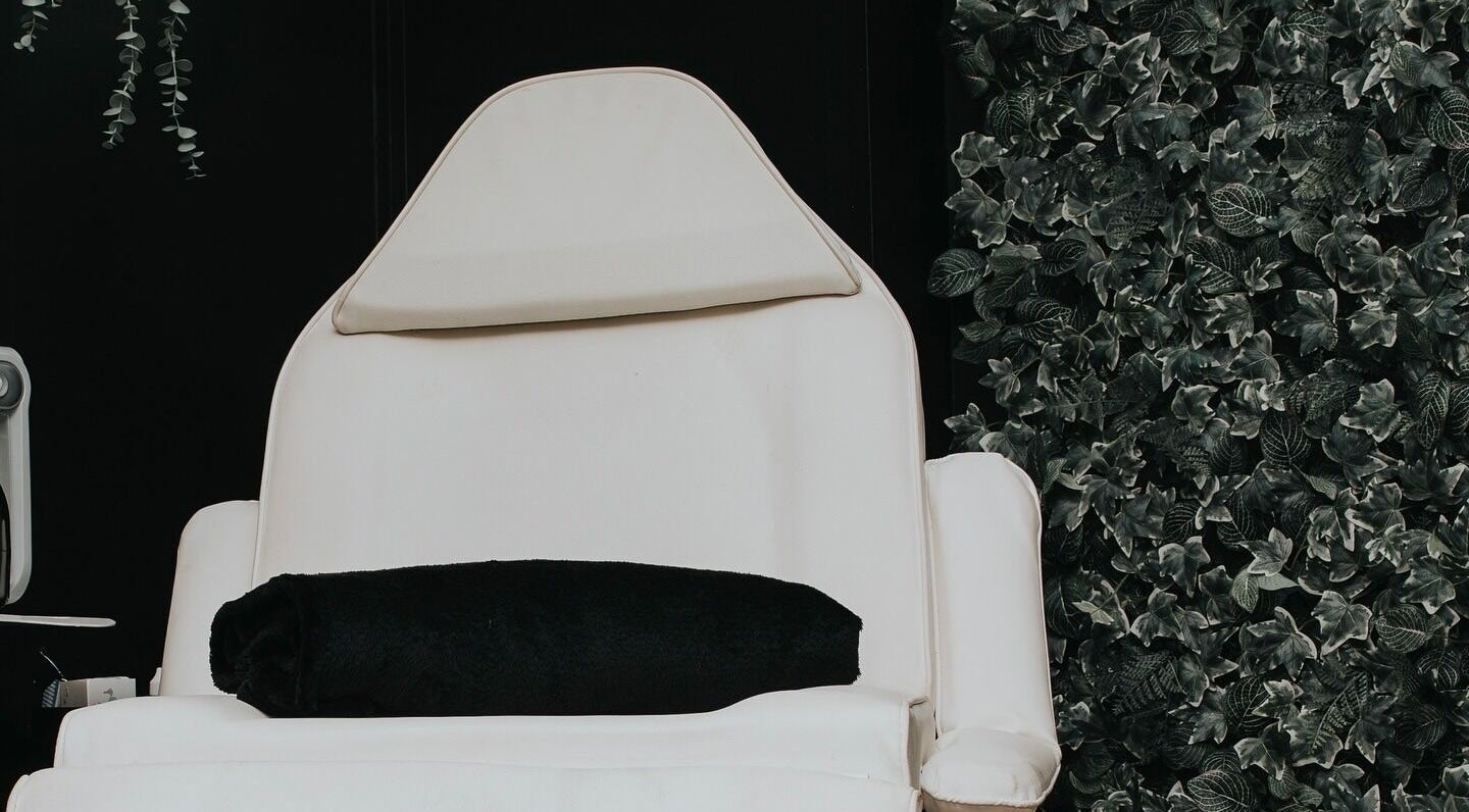 Luxury treatment chair at The Glow Up Clinic, Fareham, England, GB with lush greenery backdrop.