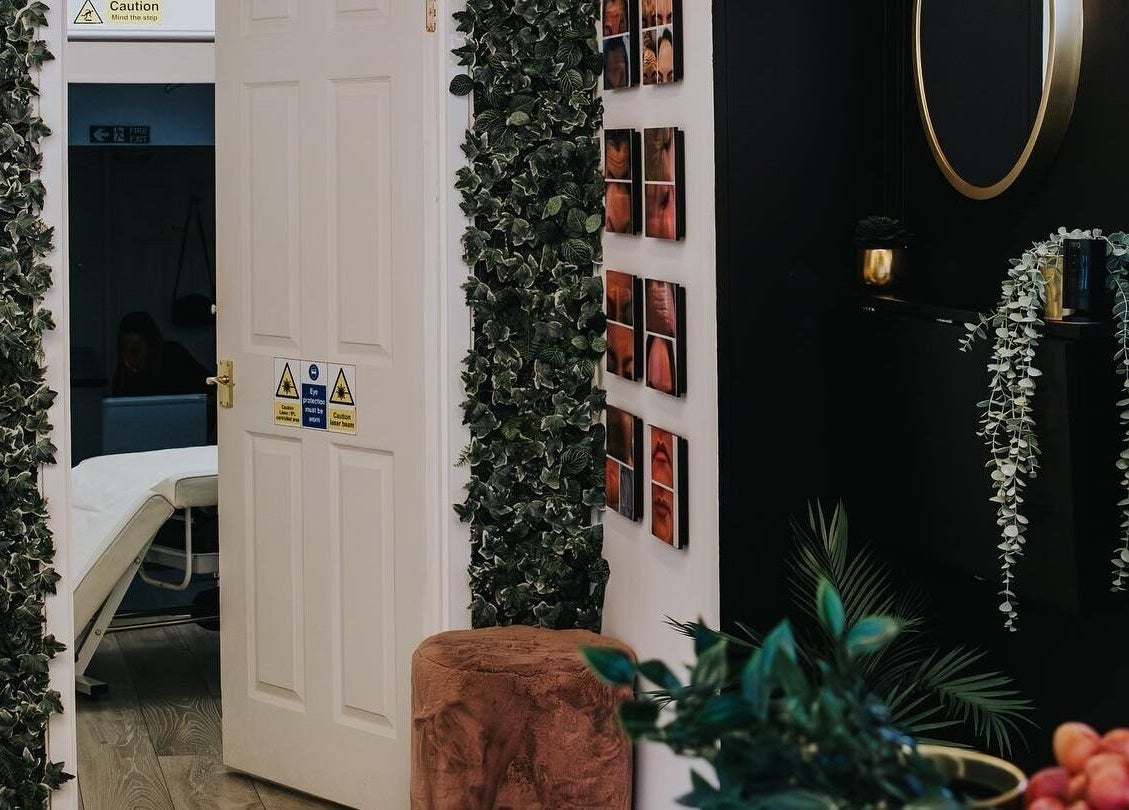 The Glow Up Clinic in Fareham, England offers a tranquil treatment room adorned with greenery and elegant decor.