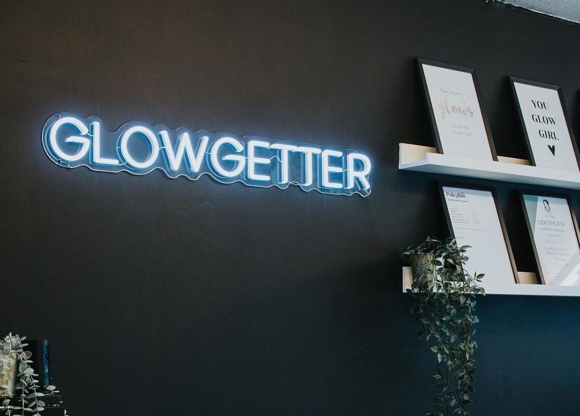 Neon 'Glowgetter' sign and certificates at The Glow Up Clinic, Fareham, England, GB showcase modern elegance.