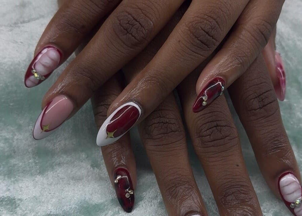 Intricate burgundy and pearl nail art at iCandy, Rodney Bay, Gros Islet, LC, showcasing elegant hand design.