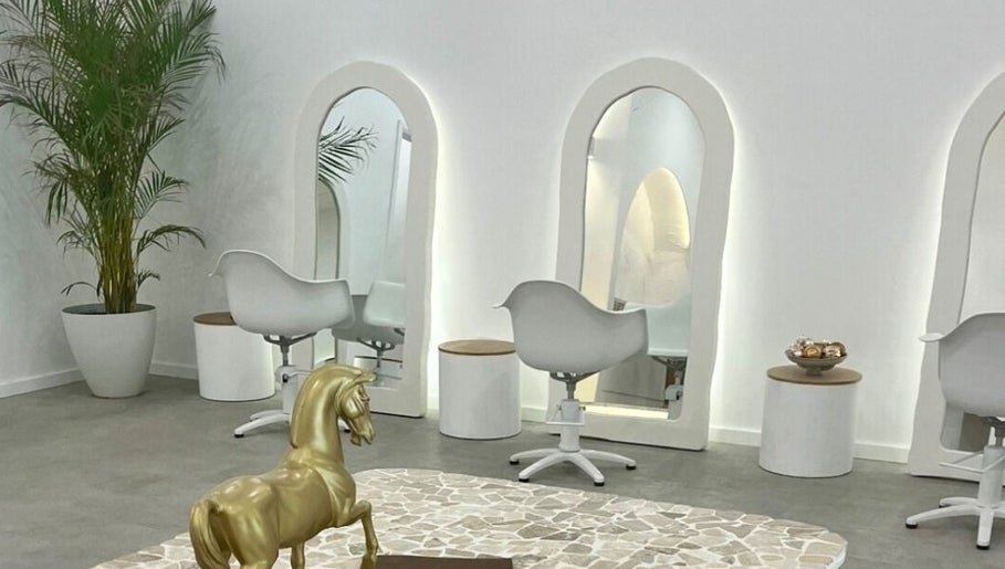 Elegant salon interior at Studio NiCHE, Adelaide, South Australia, AU featuring stylish white chairs and mirrors.