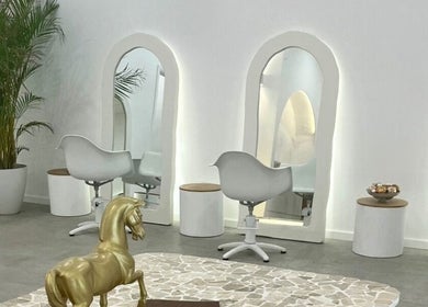 Elegant salon interior at Studio NiCHE, Adelaide, South Australia, AU featuring stylish white chairs and mirrors.