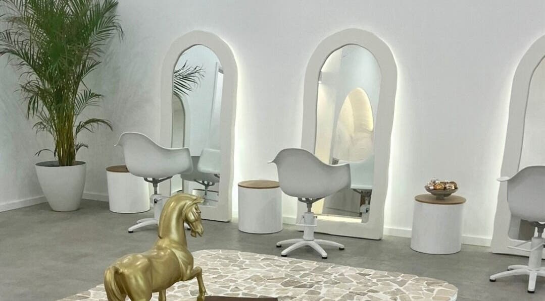 Elegant salon interior at Studio NiCHE, Adelaide, South Australia, AU featuring stylish white chairs and mirrors.