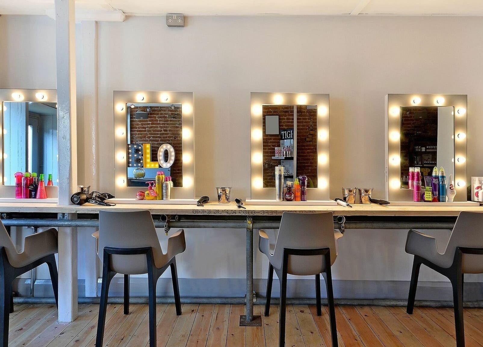 Chic beauty station at Blo by Blo in Ware, England, GB featuring illuminated mirrors and styling tools.