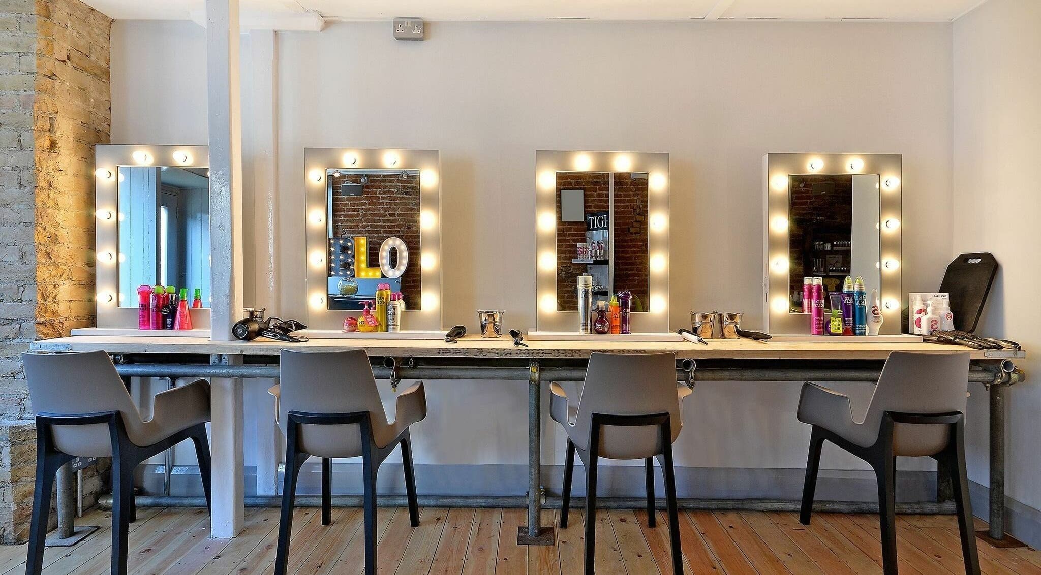 Chic beauty station at Blo by Blo in Ware, England, GB featuring illuminated mirrors and styling tools.