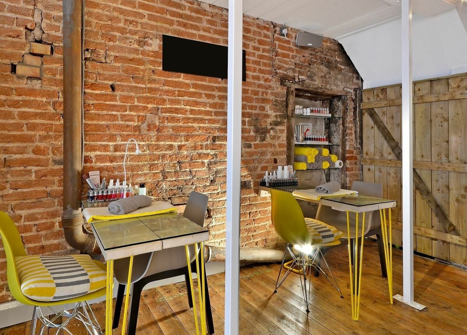 Cozy nail stations with rustic brickwork at Blo by Blo, Ware, England, GB.